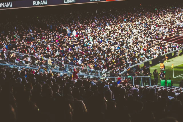 A crowded soccer stadium packed with enthusiastic fans during a match. Checking geographic audience fit for a sports property