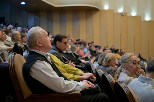 A diverse audience attentively listening during a conference in an auditorium. Choosing sponsorship benefits that reach decision-makers